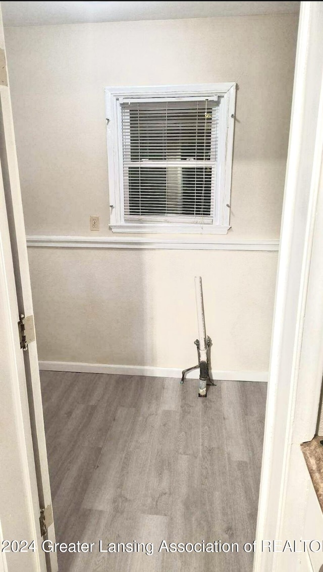 spare room featuring baseboards and wood finished floors