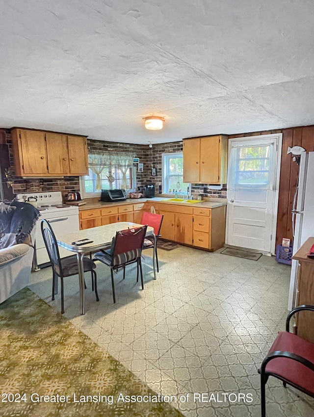 kitchen featuring sink, light tile patterned flooring, white refrigerator, and backsplash