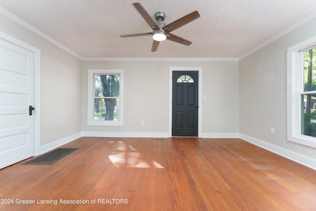 entrance foyer featuring crown molding, hardwood / wood-style floors, and a textured ceiling