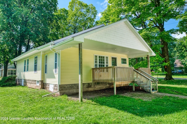 exterior space with a wooden deck and a lawn