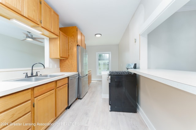 kitchen featuring sink, light hardwood / wood-style floors, ceiling fan, and appliances with stainless steel finishes