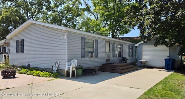 manufactured / mobile home featuring a patio area, an outdoor fire pit, central AC unit, and cooling unit