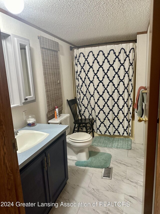 bathroom featuring tile patterned flooring, toilet, vanity, and a textured ceiling