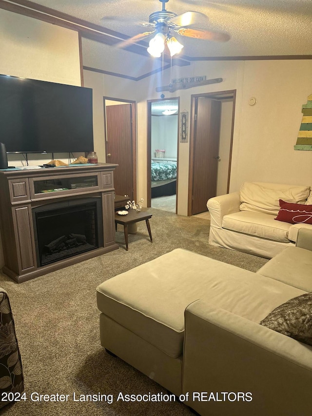 living room with ceiling fan, vaulted ceiling, carpet floors, and a textured ceiling