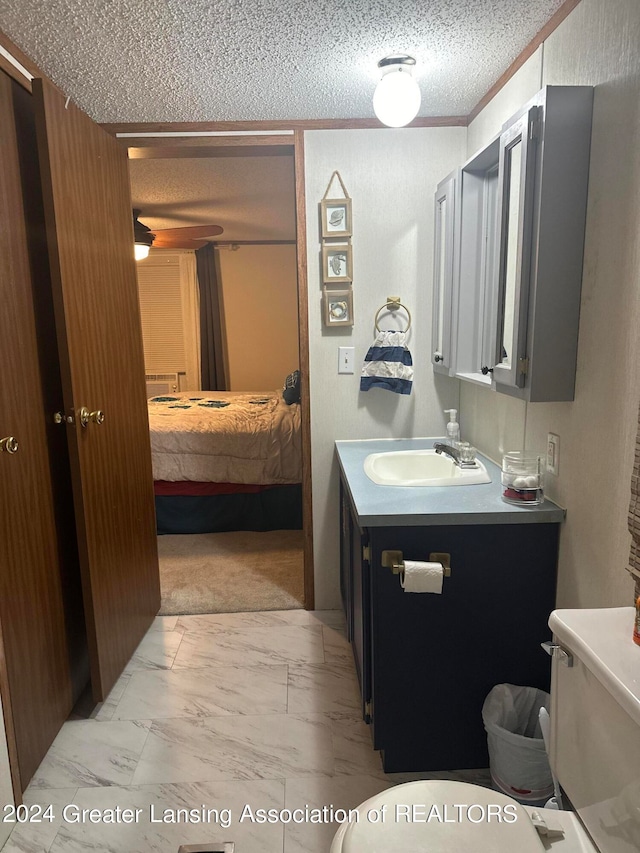 bathroom featuring tile patterned flooring, toilet, vanity, and a textured ceiling