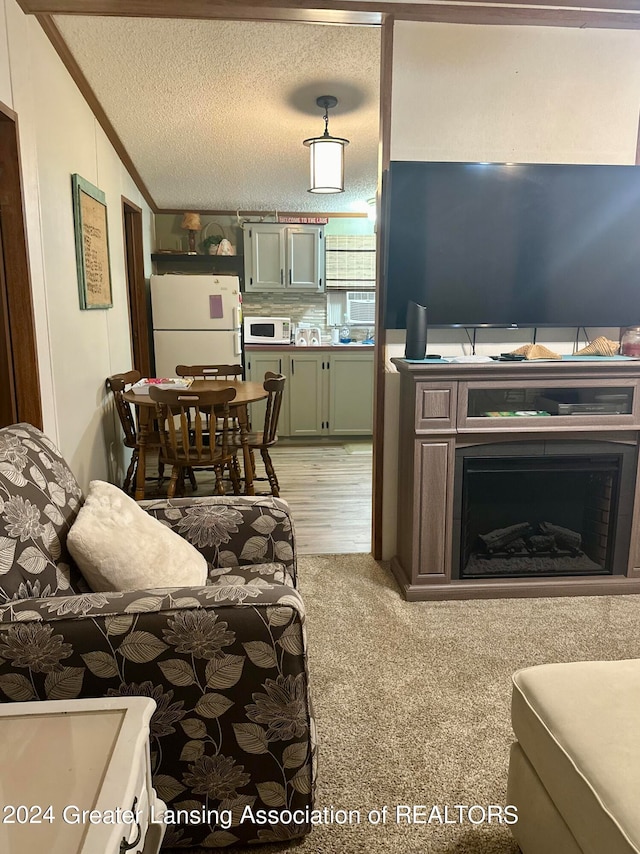 carpeted living room featuring ornamental molding, lofted ceiling, and a textured ceiling