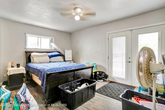 bedroom with french doors, light wood-type flooring, and ceiling fan