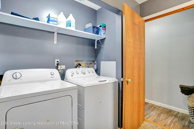 laundry area with separate washer and dryer and light wood-type flooring