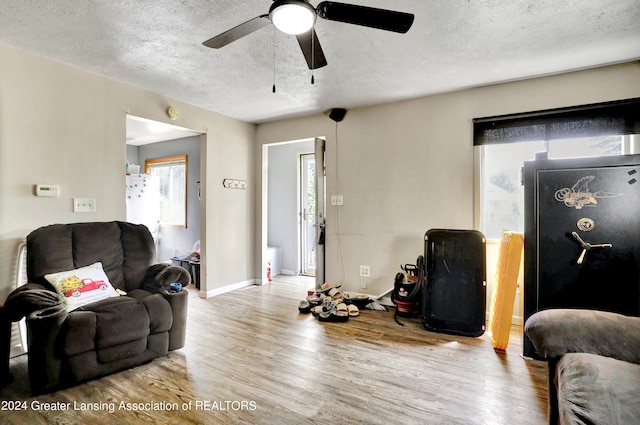 living room featuring a textured ceiling, hardwood / wood-style flooring, and ceiling fan