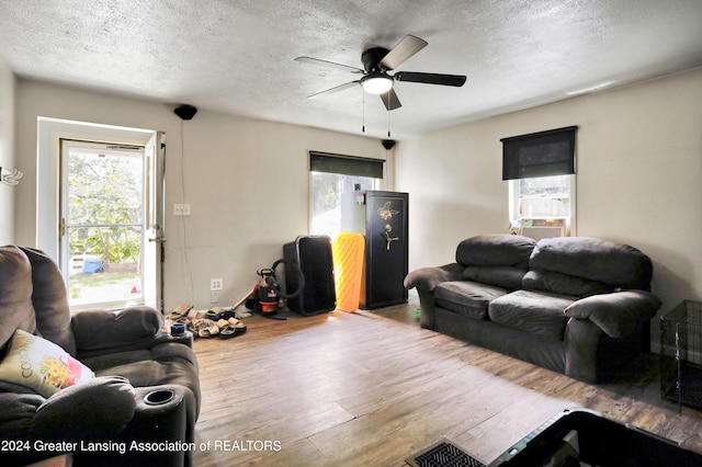 living room with a textured ceiling, hardwood / wood-style flooring, and ceiling fan