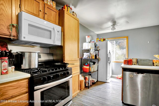 kitchen featuring light hardwood / wood-style flooring, appliances with stainless steel finishes, and ceiling fan