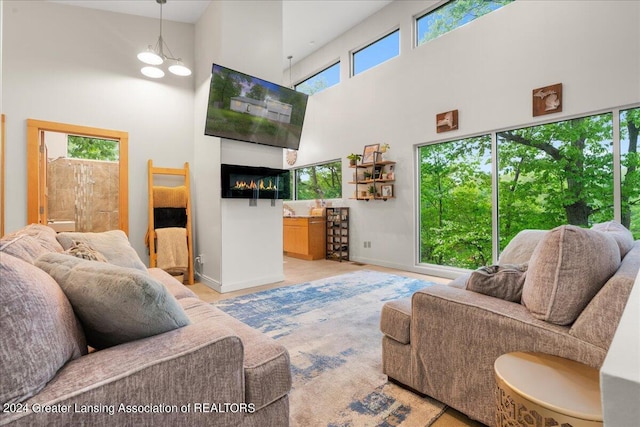 living room featuring a towering ceiling and a notable chandelier