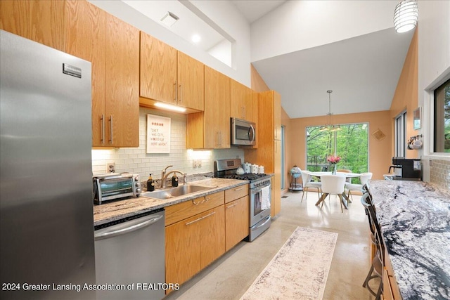 kitchen with sink, decorative light fixtures, high vaulted ceiling, stainless steel appliances, and decorative backsplash