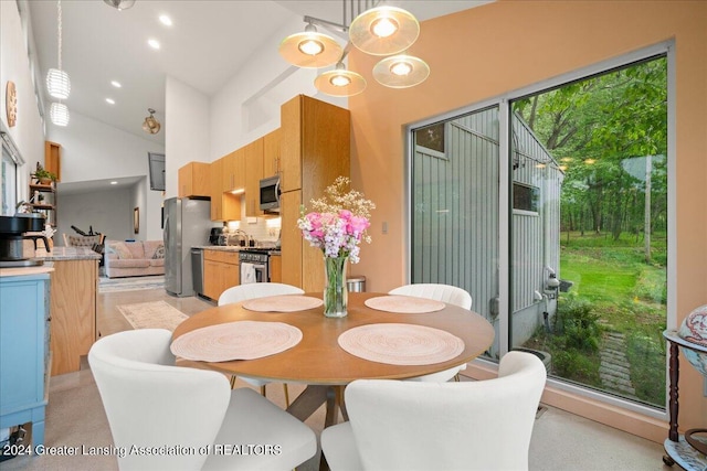 dining area featuring a towering ceiling and sink