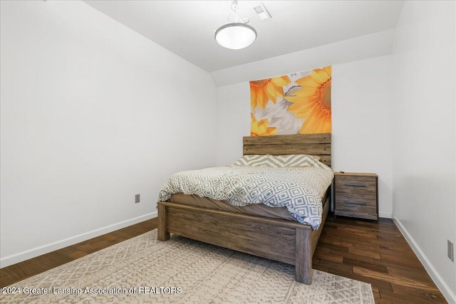 bedroom with lofted ceiling and wood-type flooring