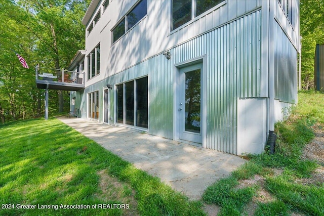 view of property exterior with a yard and a patio area