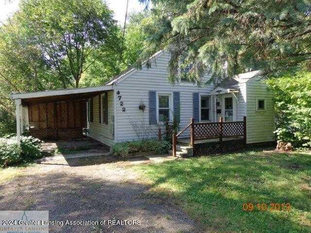 back of house featuring a carport and a yard