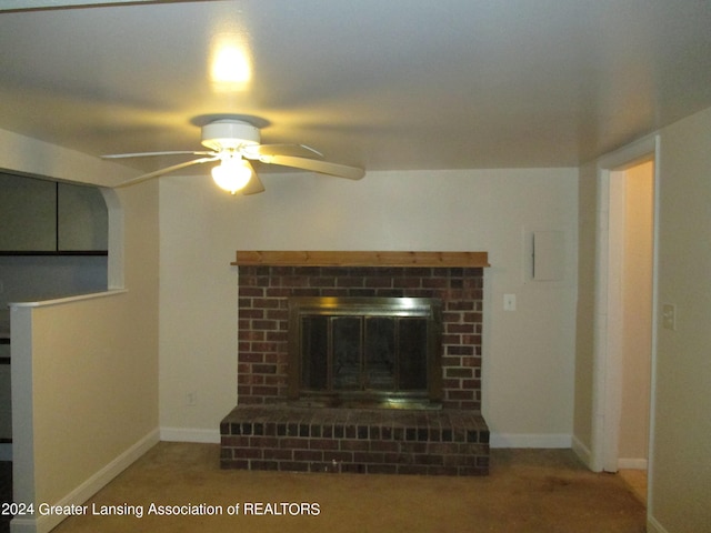 unfurnished living room featuring a brick fireplace and ceiling fan