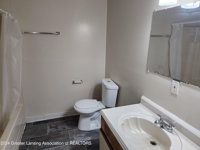 full bathroom featuring vanity, shower / bath combo with shower curtain, tile patterned flooring, and toilet