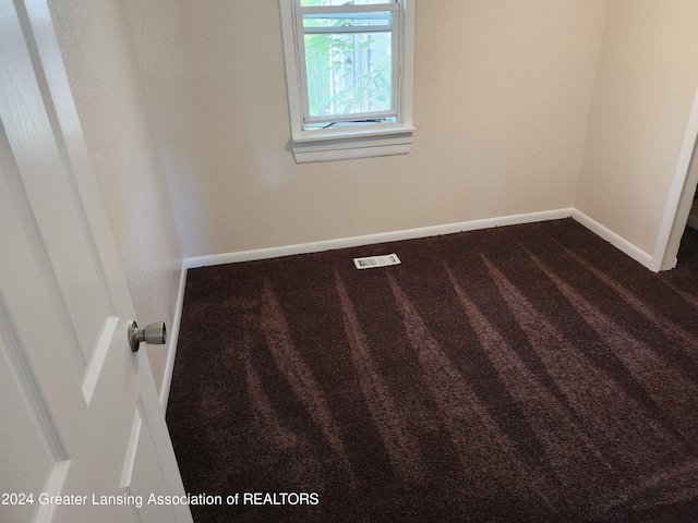 empty room with dark colored carpet