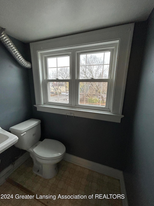 bathroom featuring tile patterned floors, a textured ceiling, and toilet