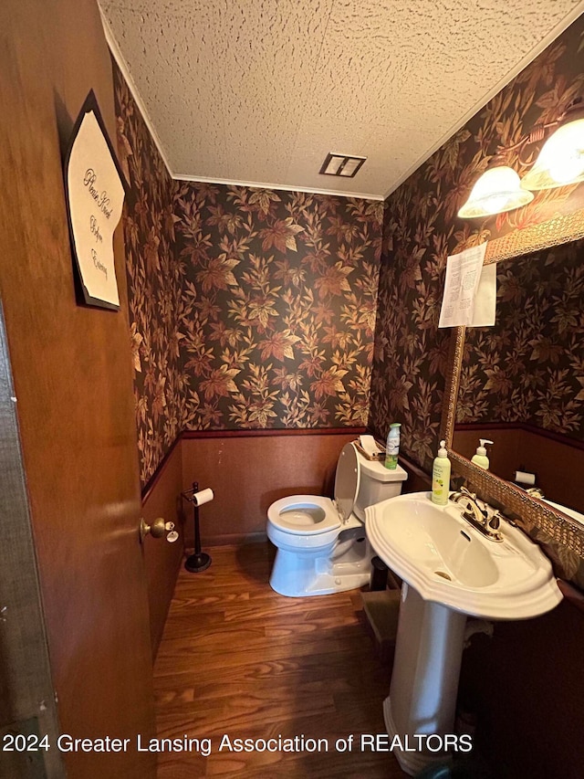 bathroom with hardwood / wood-style flooring and toilet