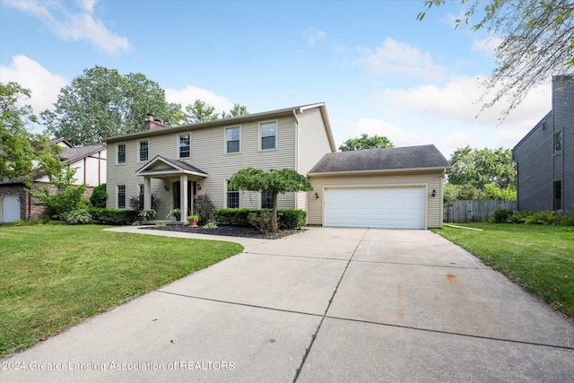 colonial home featuring a garage and a front lawn