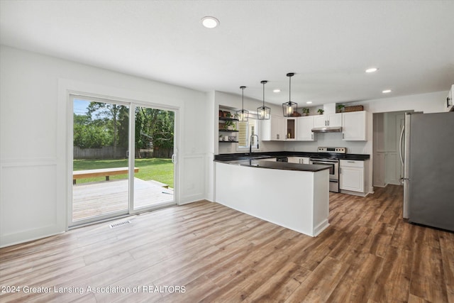 kitchen with kitchen peninsula, white cabinets, stainless steel appliances, hardwood / wood-style flooring, and sink