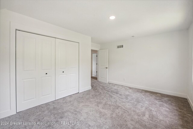 unfurnished bedroom featuring carpet and a closet