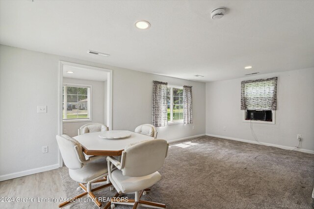 dining room with light hardwood / wood-style floors, a wealth of natural light, and cooling unit