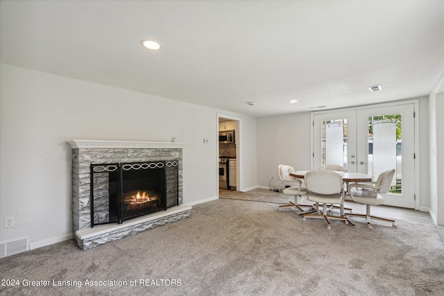 unfurnished living room with french doors, a premium fireplace, carpet, and visible vents