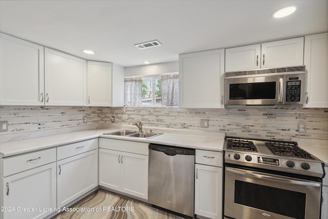 kitchen featuring visible vents, white cabinets, decorative backsplash, appliances with stainless steel finishes, and a sink