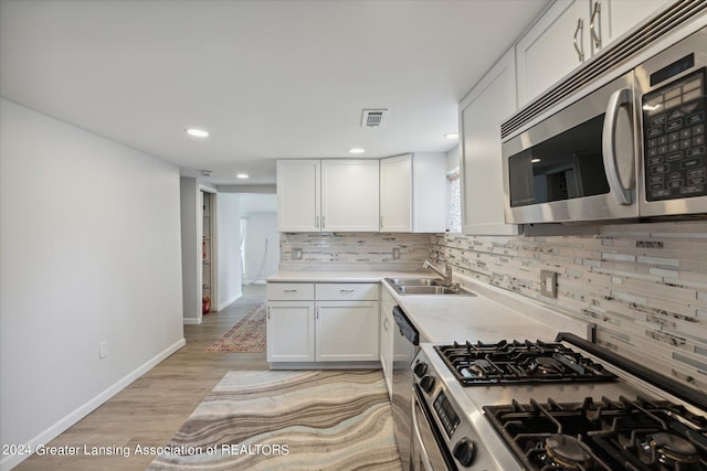 kitchen featuring stainless steel appliances, visible vents, a sink, and white cabinetry