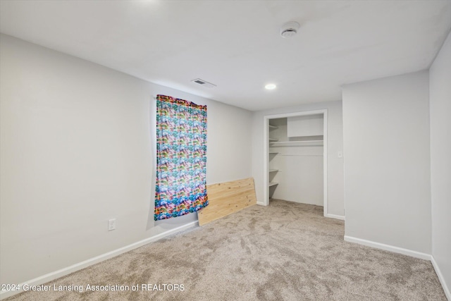 unfurnished bedroom with a closet, carpet, visible vents, and baseboards