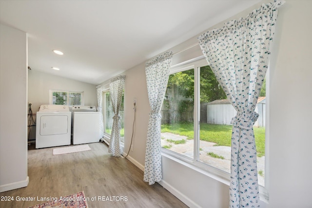 laundry area featuring washing machine and clothes dryer and light hardwood / wood-style floors