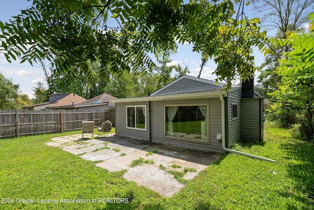 rear view of house featuring a yard and a patio area