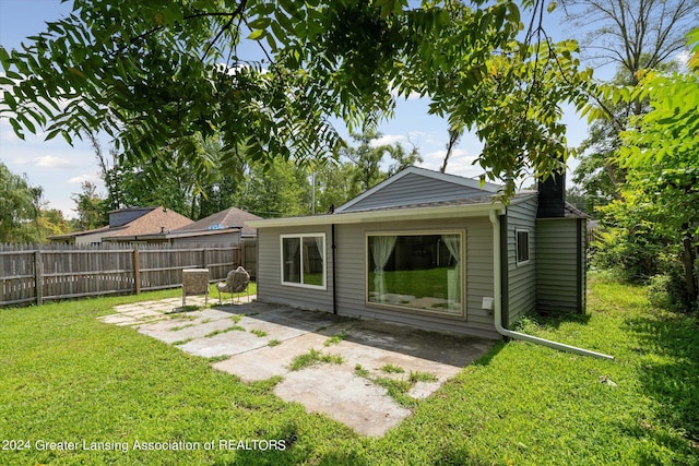 rear view of property featuring a patio, a lawn, and fence private yard