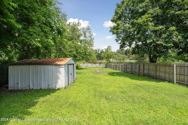 view of yard featuring an outbuilding, a shed, and a fenced backyard