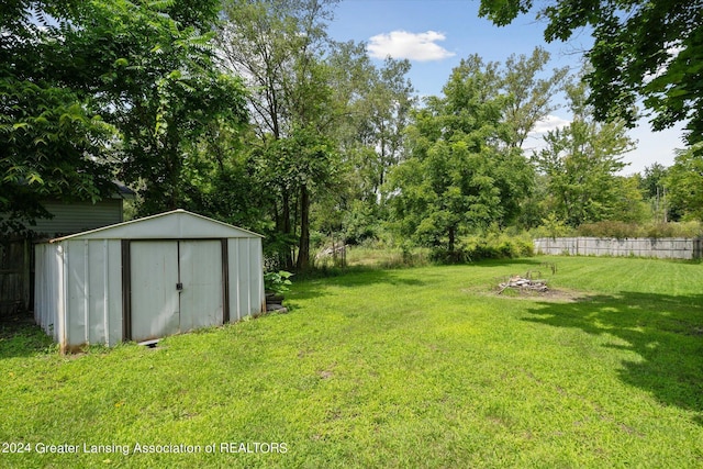 view of yard with a storage unit, an outdoor structure, and fence