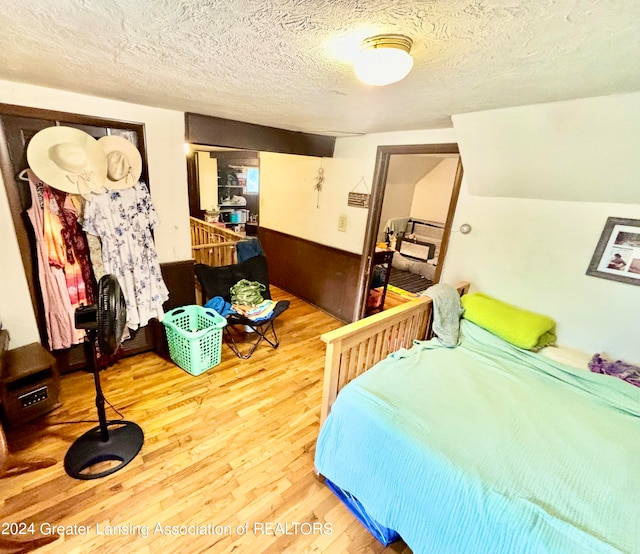 bedroom with a textured ceiling and wood-type flooring