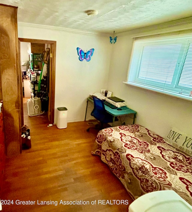 bedroom featuring hardwood / wood-style floors and a textured ceiling