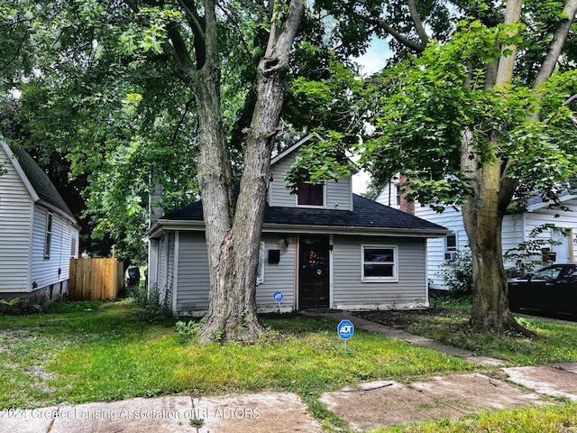 view of front of home with a chimney, fence, and roof with shingles