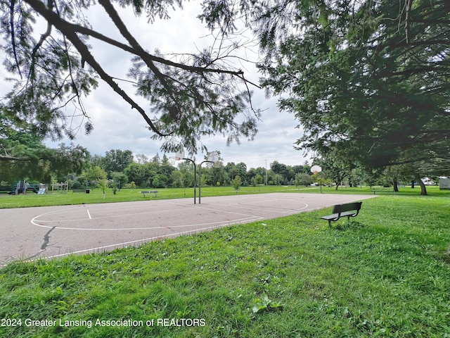 view of sport court with playground community, community basketball court, and a lawn