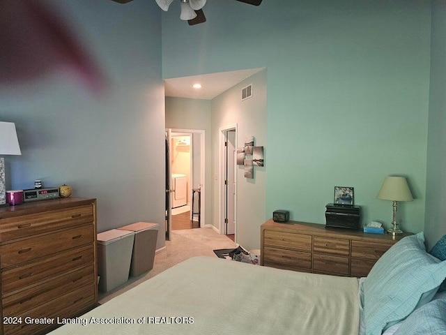 carpeted bedroom with washer / clothes dryer, ensuite bathroom, and ceiling fan