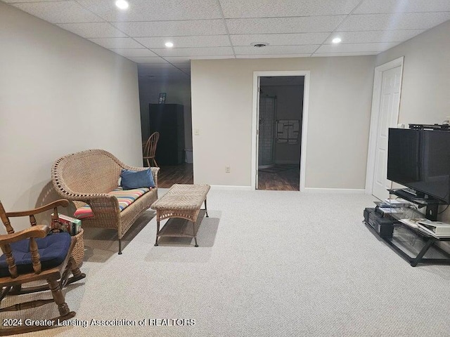 sitting room with a paneled ceiling and carpet flooring