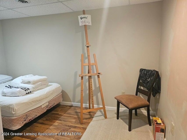 bedroom with a drop ceiling and hardwood / wood-style flooring