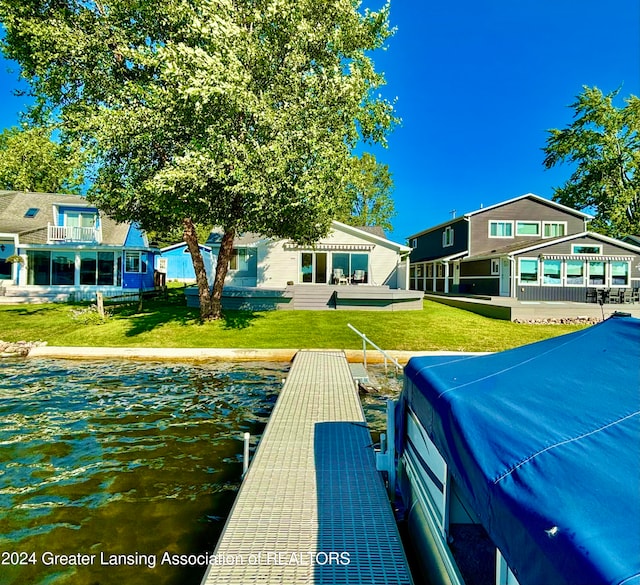 view of dock featuring a water view and a yard