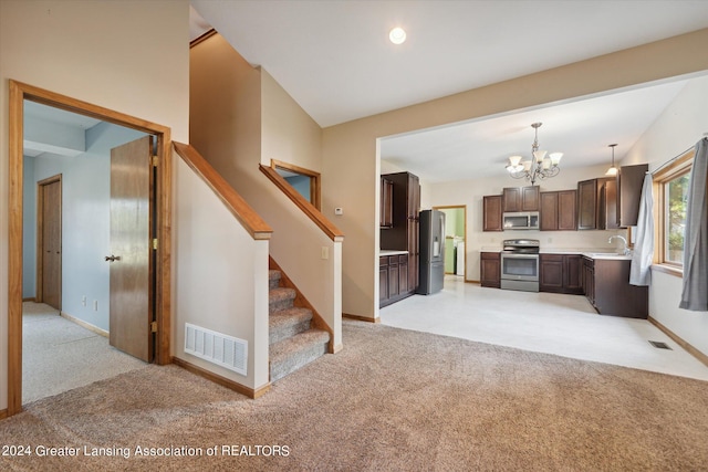 unfurnished living room featuring light colored carpet, a notable chandelier, and sink