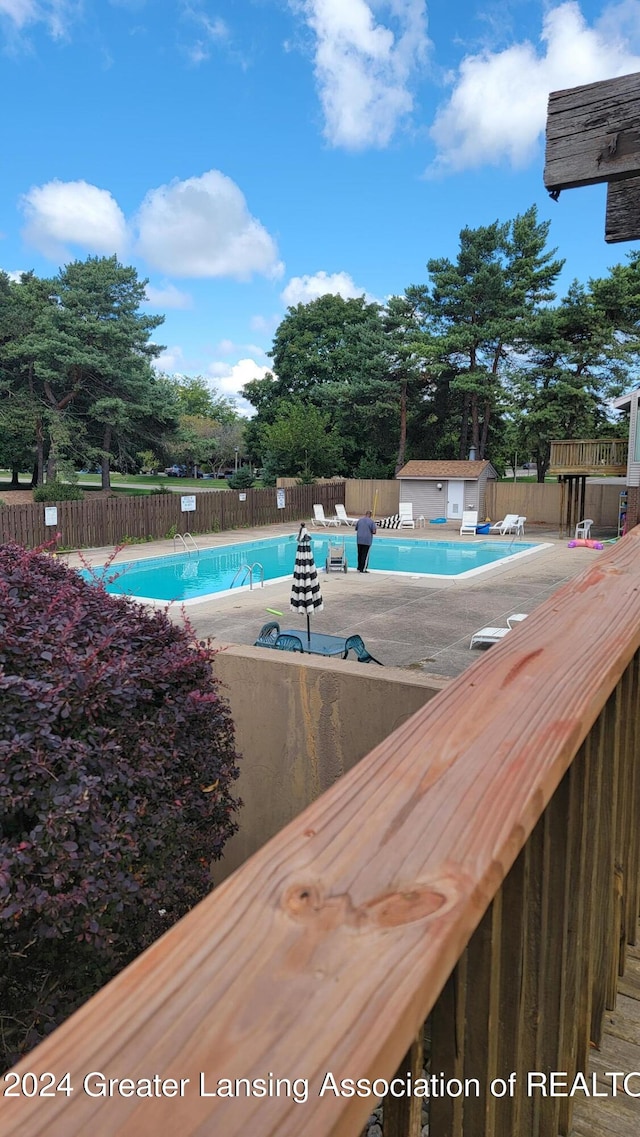 view of pool with an outbuilding and a patio area