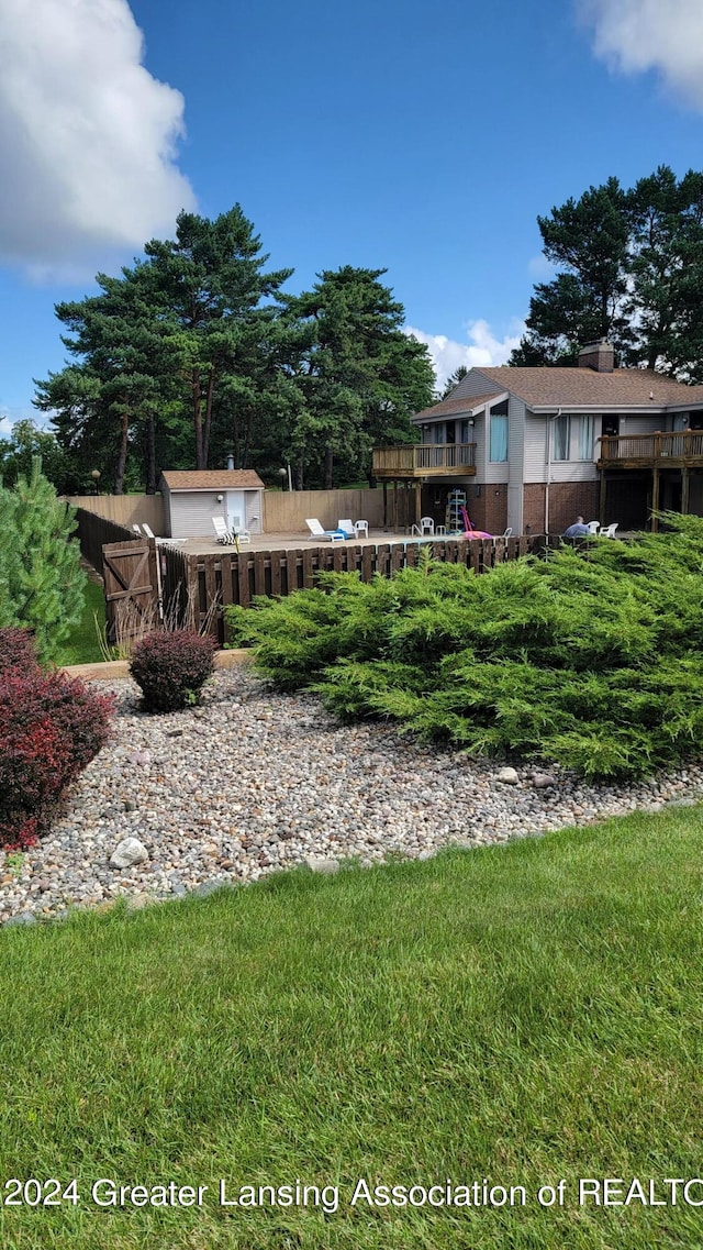 view of yard featuring a shed and a wooden deck